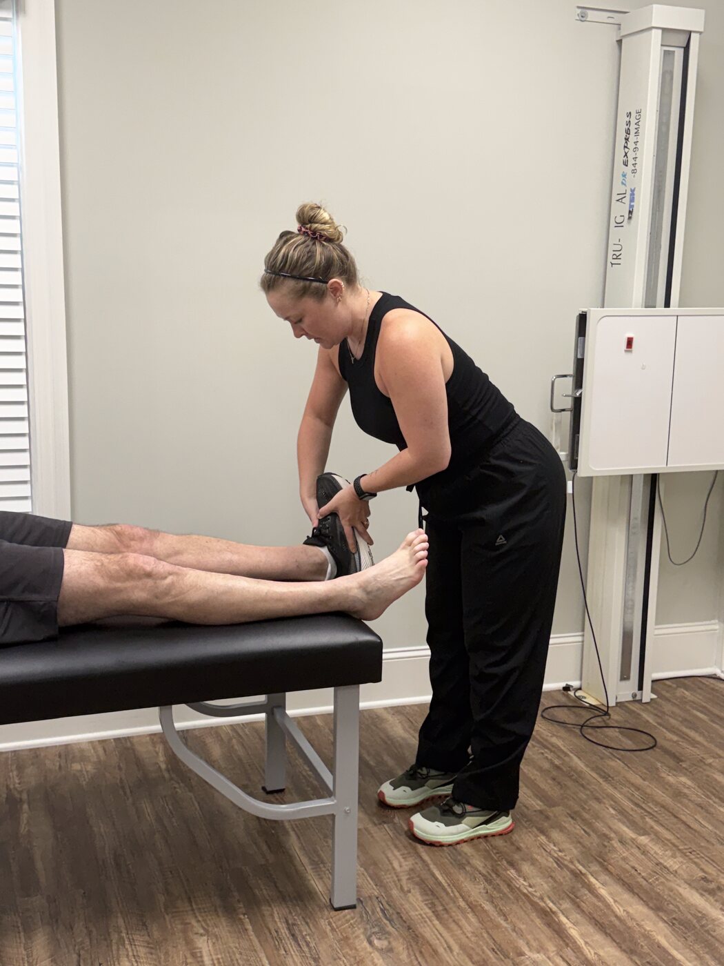 Dr. Corie Terwilliger working on a patient's foot and lower leg during a treatment session at Georgia Spine and Sports Rehab