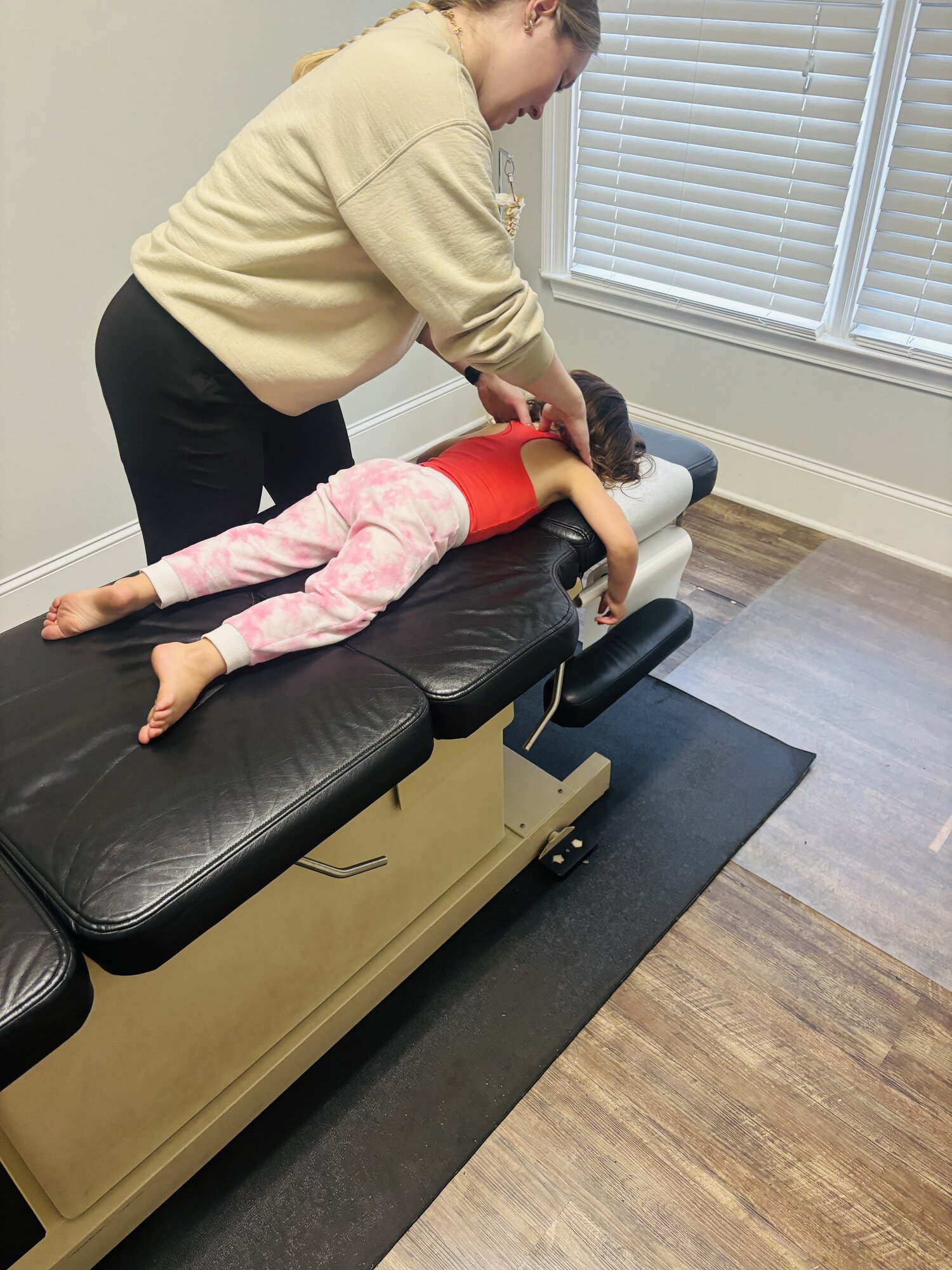 Dr. Corie Terwilliger performing a careful pediatric upper-back adjustment on a young patient in the prone position